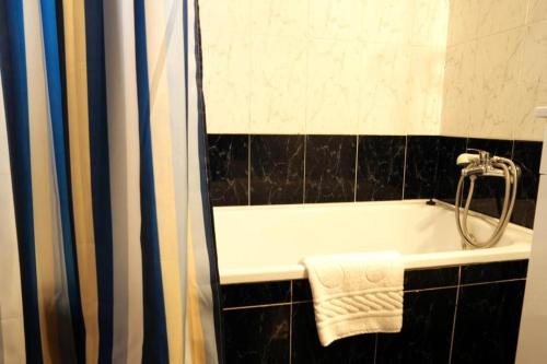 a bathroom with a bath tub with a shower curtain at Villa Francesa Guest House in Lagos