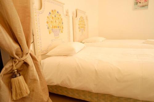 a bedroom with two beds with white sheets at Villa Francesa Guest House in Lagos