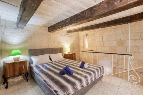 a bedroom with a bed with purple slippers on it at VLT214- Valletta 2 Bedroom Townhouse in Valletta