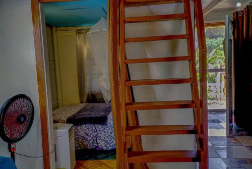a ladder leading into a room with a bedroom at My Little Cabin In Negril, cabin in Negril