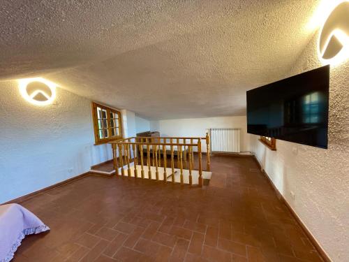 a living room with a flat screen tv on a wall at Le Vecchie Cantine in Chianni