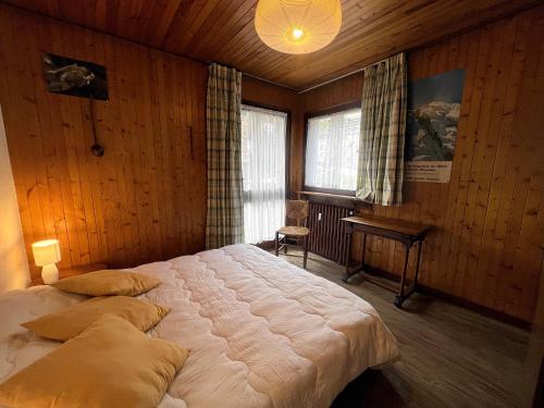 une chambre avec un grand lit dans une pièce aux murs en bois dans l'établissement Elan 19 - Appartement 3 chambres, à La Clusaz