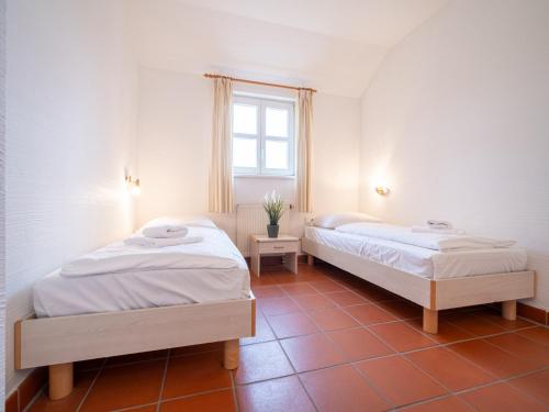une chambre avec deux lits et une fenêtre dans l'établissement Feriendorf Rugana - Budget Appartement mit 2 Schlafzimmern und Terrasse A26, à Dranske