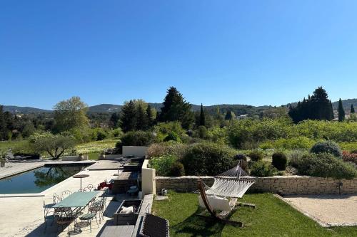 une cour arrière avec une piscine et des chaises à côté d'une piscine dans l'établissement La Belle de Lagnes, à Lagnes