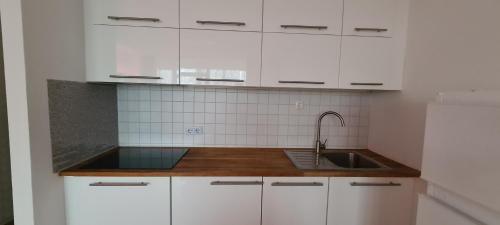 a kitchen with white cabinets and a sink at Equipment of Good And Night in Neuss