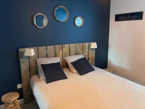 um quarto com uma cama com duas almofadas e dois espelhos em la petite terrasse d’Arthur; appartement terrasse à 50m de la mer em Le Portel