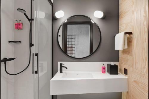 a bathroom with a sink and a mirror at Moxy Bucharest Old Town in Bucharest