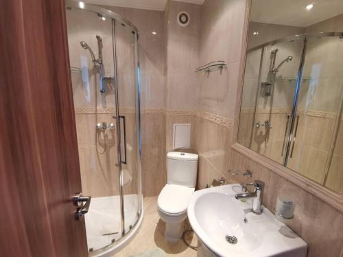 uma casa de banho com um WC, um chuveiro e um lavatório. em Milana-2 Sea View em Byala