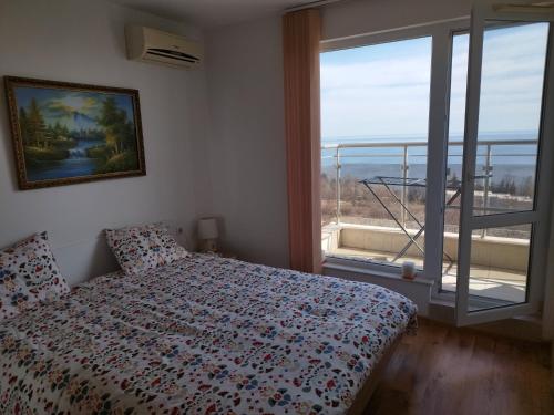 a bedroom with a bed and a large window at Milana-2 Sea View in Byala