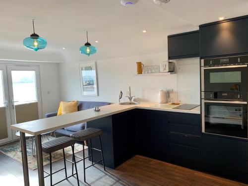 a kitchen with black cabinets and a counter top at Modern studio apartment with stunning views! in St Ives