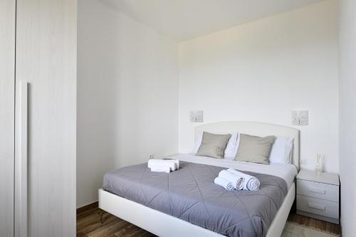 een witte slaapkamer met 2 handdoeken op een bed bij Casa Jerzu S'essia de su santu in Jerzu