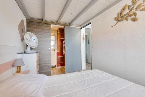 1 dormitorio blanco con 1 cama y ventilador en Face mer - Trou du Diable sur la Corniche, en Les Bussolleries