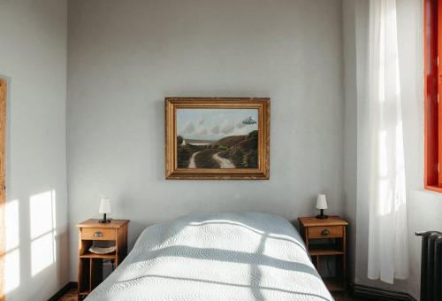 a bedroom with a bed and a painting on the wall at Schloss Schmarsow, Wohnung BLAU 
