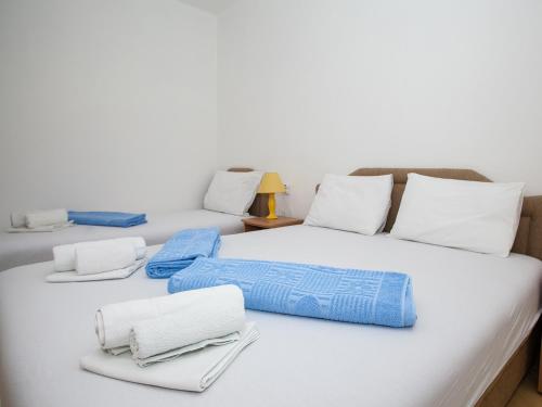 two beds with white and blue towels on them at Daria Apartments in Kotor