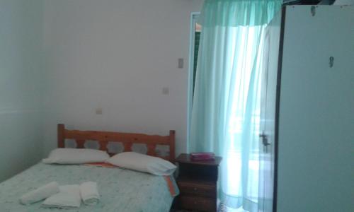 a bedroom with a bed with two towels on it at Manoleas Rooms to Let in Leonidio