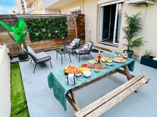 - une table de pique-nique avec de la nourriture sur la terrasse dans l'établissement Les Néréides - T3 à 50m de la plage - Clim - Terrasse & BBQ - Wifi/Netflix, à Valras-Plage