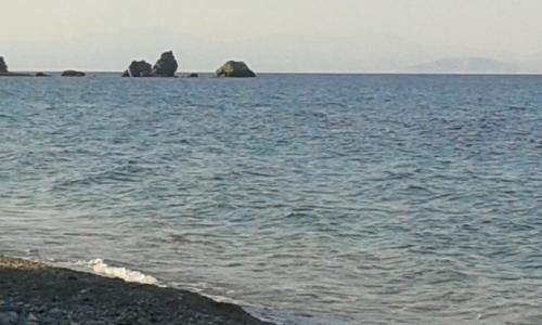 a large body of water with rocks in the distance at Manoleas Rooms to Let in Leonidion