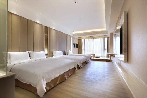 礁溪鄉的住宿－葛瑪蘭之星飯店，酒店客房内的一排床位