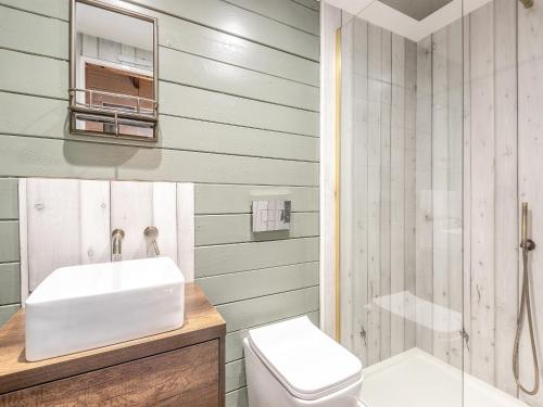 a bathroom with a sink and a toilet and a shower at Little Yew Tree Lodge in Hambledon