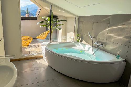 a bath tub in a bathroom with a toilet at Alfea Deluxe Loft & Rooms in Trento