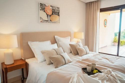 duże białe łóżko w pokoju z oknem w obiekcie Los Piños, 2 Bedroom Apartment with panoramic view w mieście Benahavís