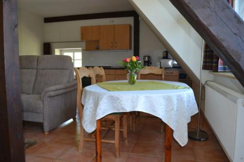 uma cozinha com uma mesa com um vaso de flores em Ferienhof Gosch em Rendsburg