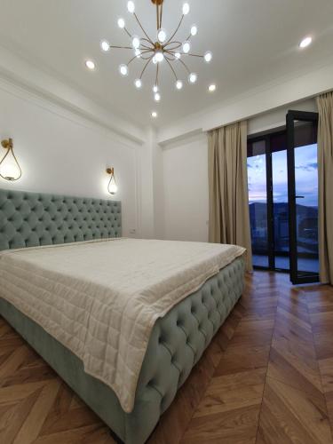 Un dormitorio con una cama grande y una lámpara de araña. en Old City Apartment, en Tiflis