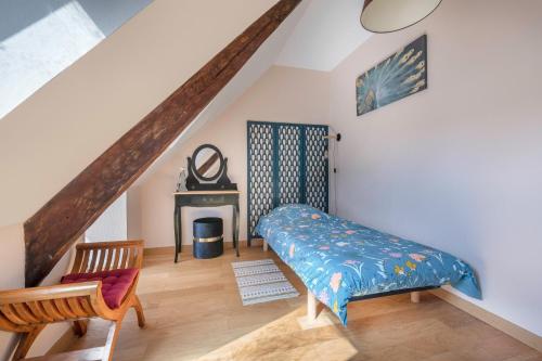 a bedroom with a bed and a chair and a staircase at Charmante maison entre La Baule et Guerande in Guérande