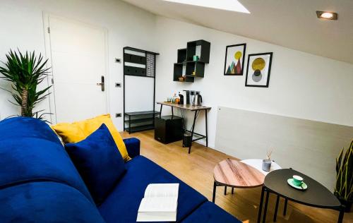 a living room with a blue couch and a table at Alfea Deluxe Loft & Rooms in Trento