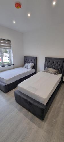 two twin beds in a room with at Modern 2BD Flat in London