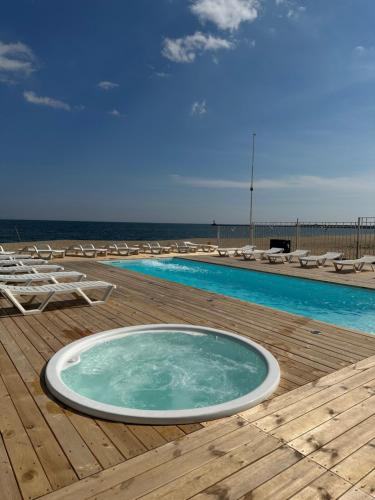 una bañera de hidromasaje en una terraza junto al océano en Apart-Hotel Poseidon, en Odessa