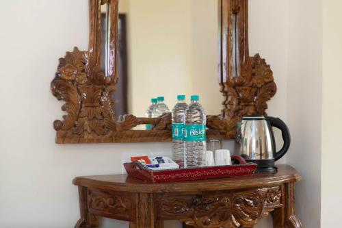 a table with two mirrors and water bottles on it at Yogved Hospitality & Resort in Rishīkesh