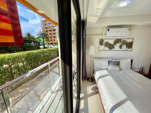 1 dormitorio con 1 cama y balcón en 777 Beach condo - family condo near Mai Khao beach en Ban Mai Salae