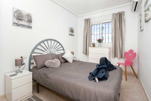 - une chambre avec un lit et une chaise rose dans l'établissement CH Grazalema La Marquesa, à Ciudad Quesada
