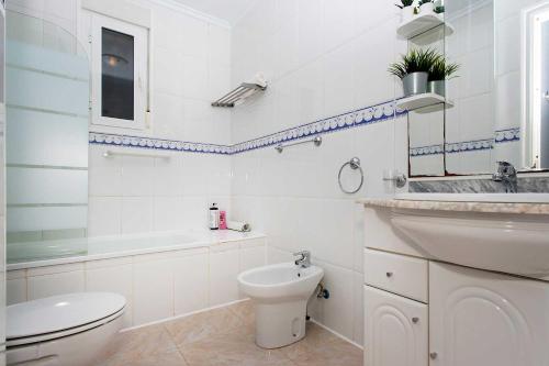 La salle de bains blanche est pourvue de toilettes et d'un lavabo. dans l'établissement CH Grazalema La Marquesa, à Ciudad Quesada