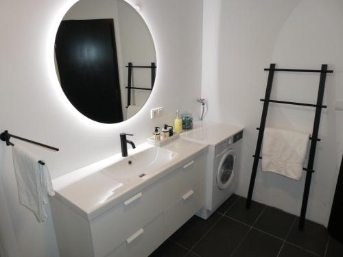 a bathroom with a sink and a mirror and a washing machine at Northberg Apartments in Keflavík