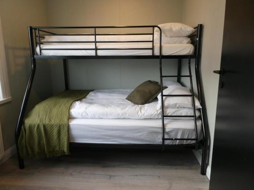 a bunk bed with white sheets and a pillow at Northberg Apartments in Keflavík