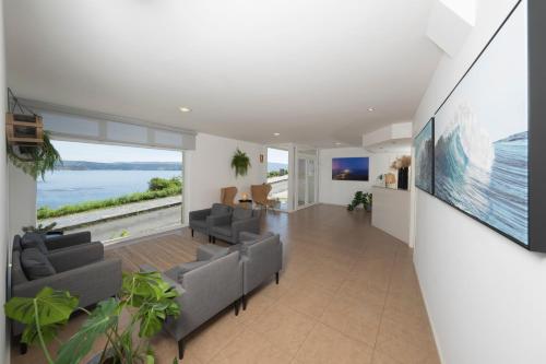 ein Wohnzimmer mit Sofas und einem großen Fenster in der Unterkunft Hotel Mar de Fisterra in Kap Finisterre