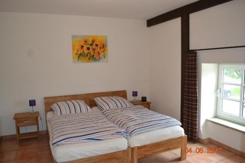 uma cama num quarto com um quadro na parede em Ferienhof Gosch em Rendsburg