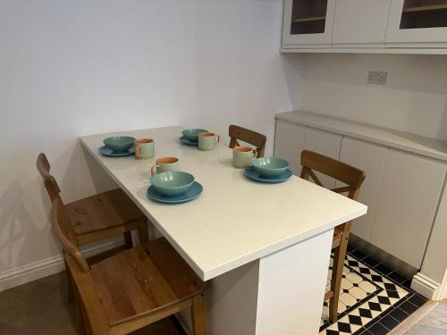 a kitchen with a table with bowls and plates on it at Knightsbridge Harrods Apartment in London