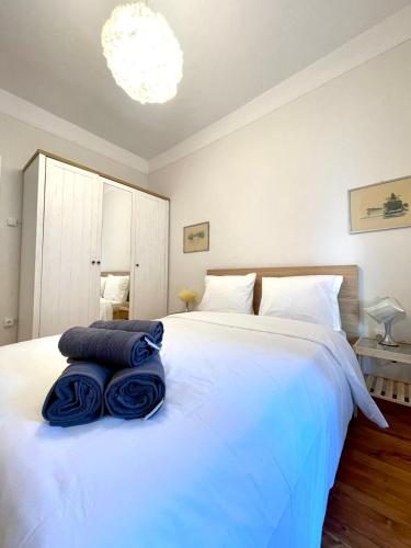 - une chambre avec un lit blanc et des serviettes bleues dans l'établissement Skra 3 by Agora Flats, à Thessalonique