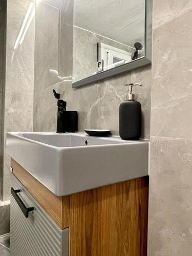 - un lavabo dans la salle de bains avec un distributeur de savon dans l'établissement Skra 3 by Agora Flats, à Thessalonique