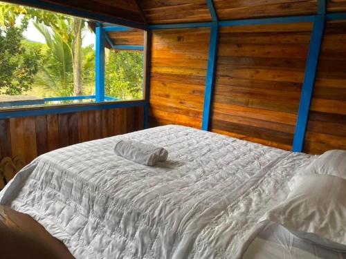 カッティエンにあるNgọc Tiên Farmer Eco Lodge Cat Tiênの窓付きの客室で、白い大型ベッド1台が備わります。