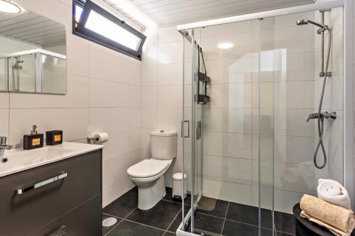 a bathroom with a toilet and a glass shower at Panoramic Views I I in Caniço