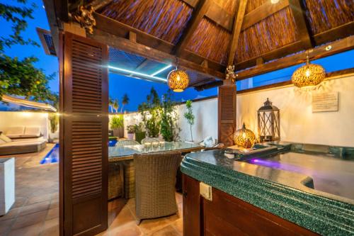 une cuisine extérieure avec un bar et une terrasse dans l'établissement El Valle Golf Resort Villa private pool hot tub and sauna, à Baños y Mendigo