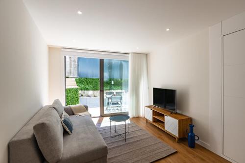 a living room with a couch and a television at Pestana Apartments - Premium in Porto