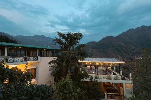 a view of a building with mountains in the background at Yogved Hospitality & Resort in Rishīkesh