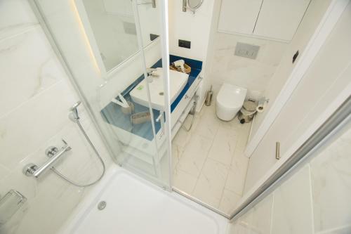 a white bathroom with a sink and a toilet at Batumi River Source in Batumi