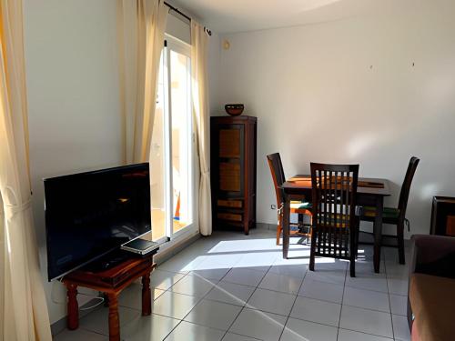 sala de estar con TV, mesa y sillas en Spectacular Sea views 2 bedrooms in Villa Marina, en Benidorm