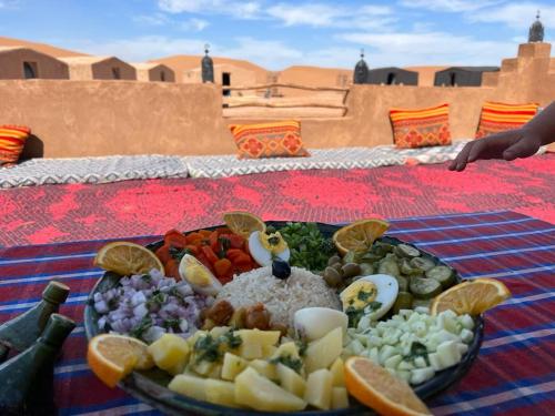 Bivouac Le charme d'Aladdin في El Gouera: طبق من الطعام على طاولة في الصحراء